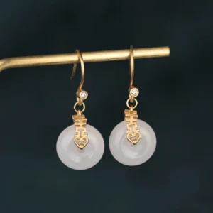 White jade double happiness fortune earrings with gold hardware close-up front view