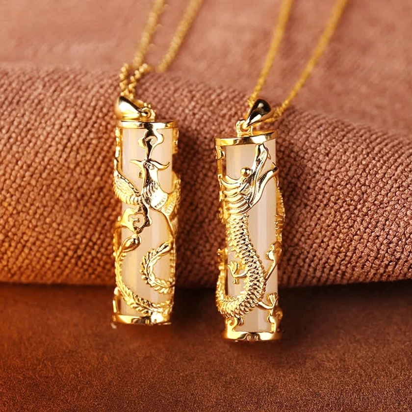 Loose white jade dragon and phoenix pendants showing detailed hand-carved relief work and glossy natural jade finish