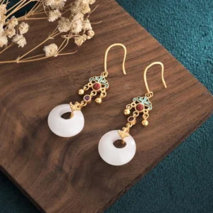 Handmade white jade drop earrings on wooden tray with dried flowers, feng shui blessing design