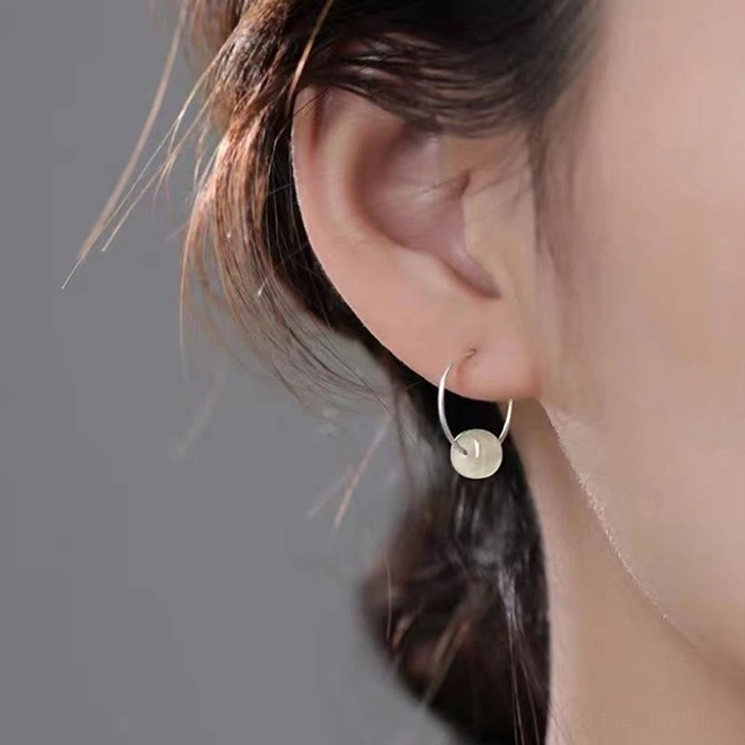 White jade earrings worn on ear - delicate white jade drop sterling silver studs in real daily wear scenario showing elegant subtle fit