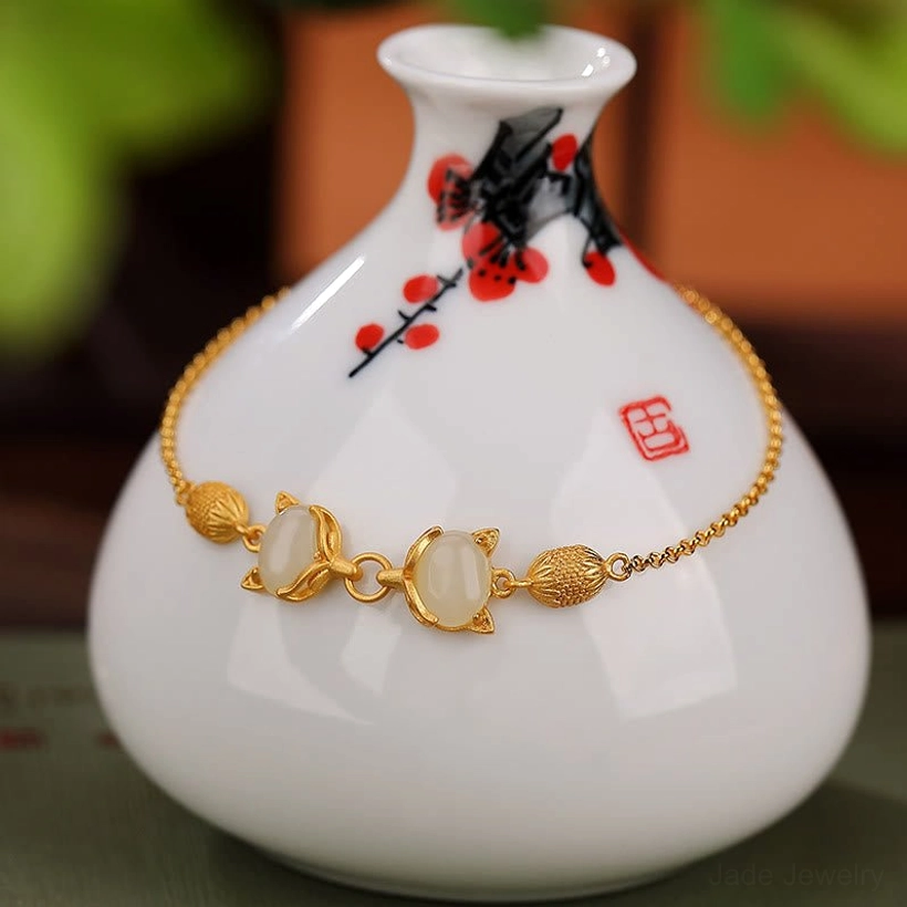 White jade fox bracelet close-up showing pristine jade stones and silver fox hardware on vase background