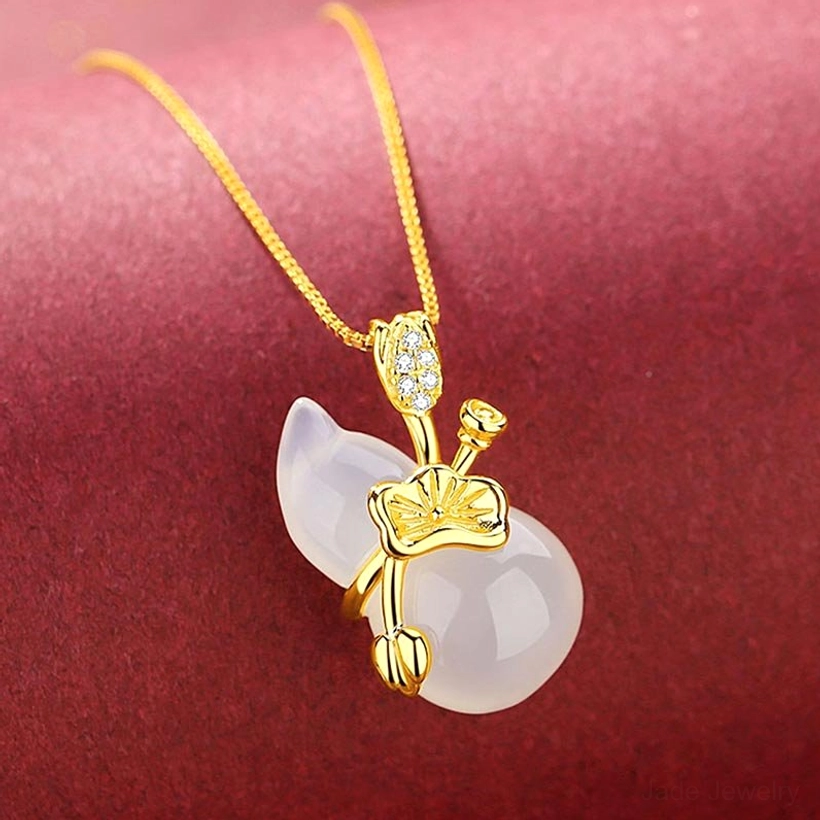 Close-up side view of white jade gourd pendant with polished stone and gold-toned decorative parts on delicate gold chain