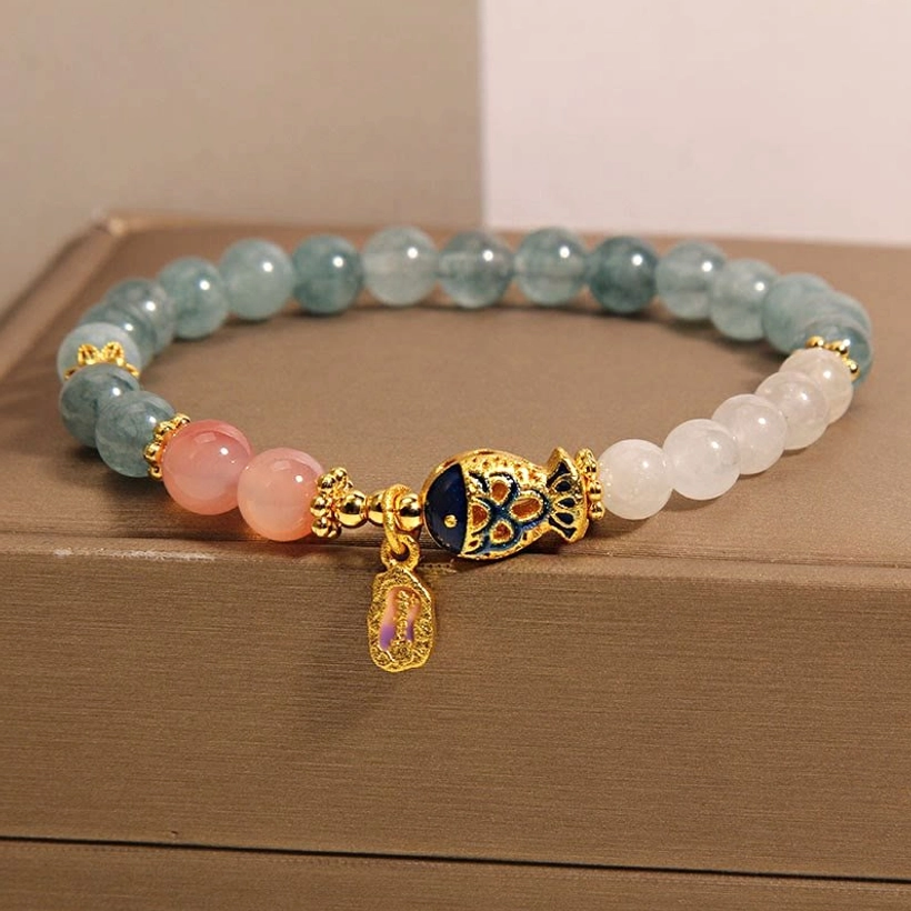 White jade koi fish luck bracelet low front angle showing gold enamel hardware and stone details