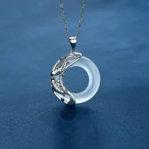 Natural white jade koi necklace featuring circular translucent jade pendant with silver koi carving and delicate chain