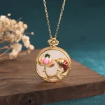 White jade koi fish lotus pendant necklace front view with cloud-shaped clasp, gold-tone metal accents, and enamel-painted red koi and pink lotus motifs on genuine jade