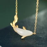 White jade koi fish pendant necklace with 925 sterling silver chain, front close-up view showing hand-carved koi detail and smooth matte white jade body on dark background