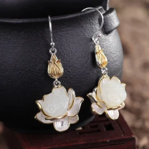 Pair of white jade lotus drop earrings hanging display showing silver ear hooks and two-tone metal finish