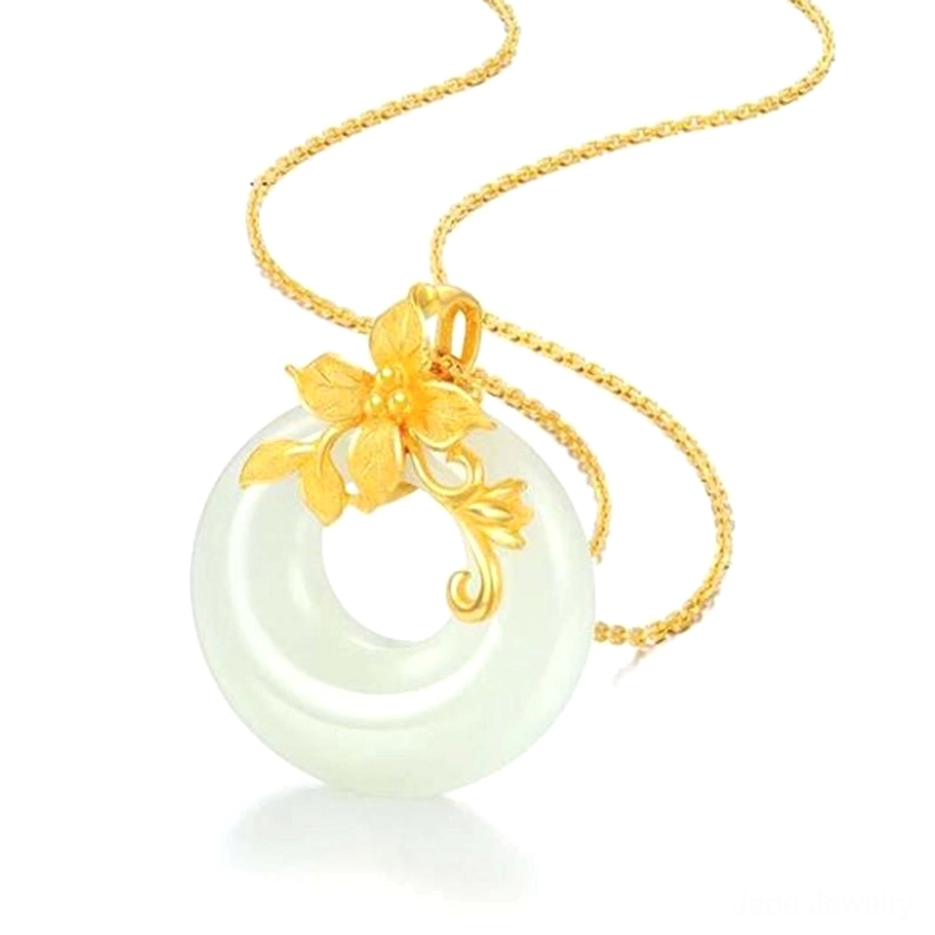 White jade lotus necklace with gold pendant and delicate chain, front overhead view showcasing the circular jade donut with intricate lotus-inspired gold clasp and twisted gold chain detail