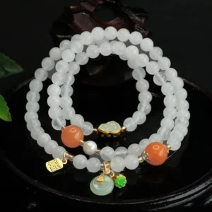 Top-down view of handcrafted white jade peace buckle bracelet featuring jade pendant and gold Fu tag on wooden surface