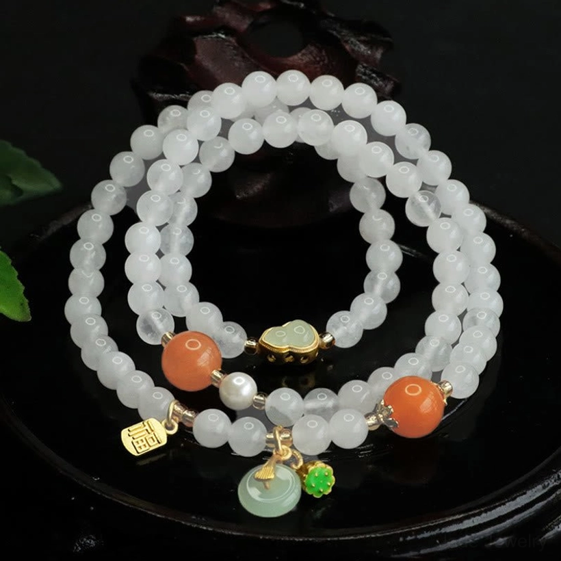 Top-down view of handcrafted white jade peace buckle bracelet featuring jade pendant and gold Fu tag on wooden surface