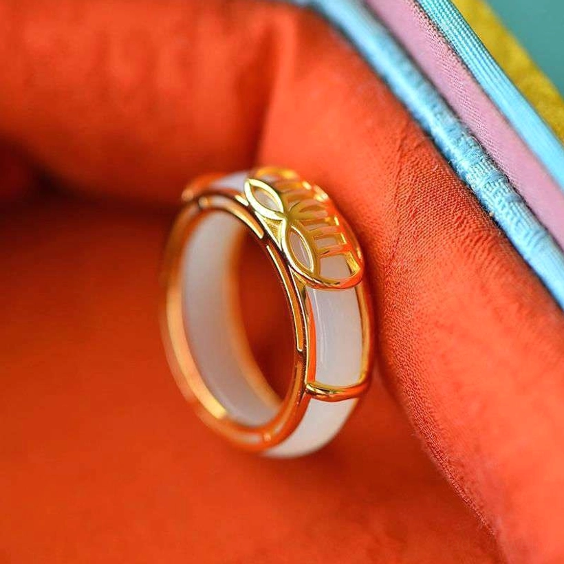 Close-up side view of white jade lucky ring showing smooth jade insert and polished gold-plated frame detail