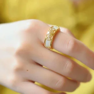 White jade protection ring worn on index finger, showcasing minimalist gold-plated dual-tone design and natural jade luster