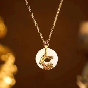 Close-up detailed view of white jade peace buckle pendant with intricate sterling silver peony design and hand motif on golden bokeh background