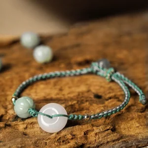 White jade peace buckle pumpkin bead braided bracelet on wooden surface with green woven cord