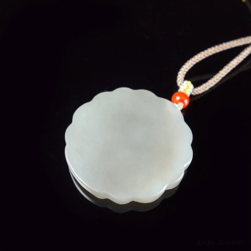 Reverse side of white jade peacock pendant showing smooth plain back of natural jade stone