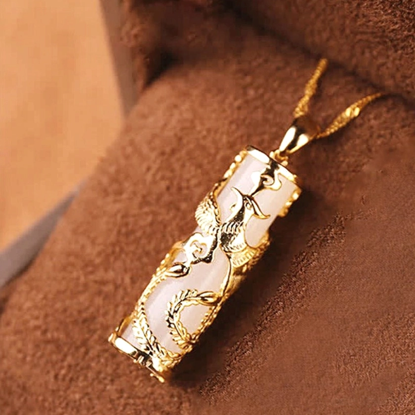 Phoenix-style white jade pendant necklace with gold electroplated copper setting and delicate chain, low angle side view on neutral background