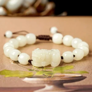 Premium white jade Pixiu bracelet featuring barrel-shaped beads and carved jade charm with brown string
