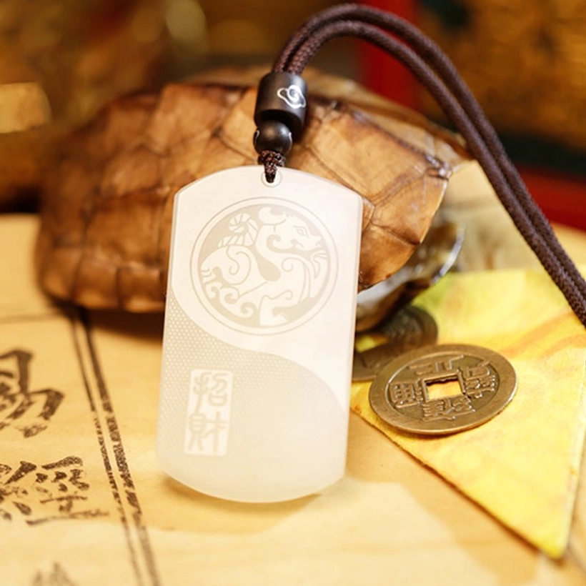 Close-up of white jade Pixiu pendant showing clear mythical beast carving and Zhao Cai stamp on turtle shell background
