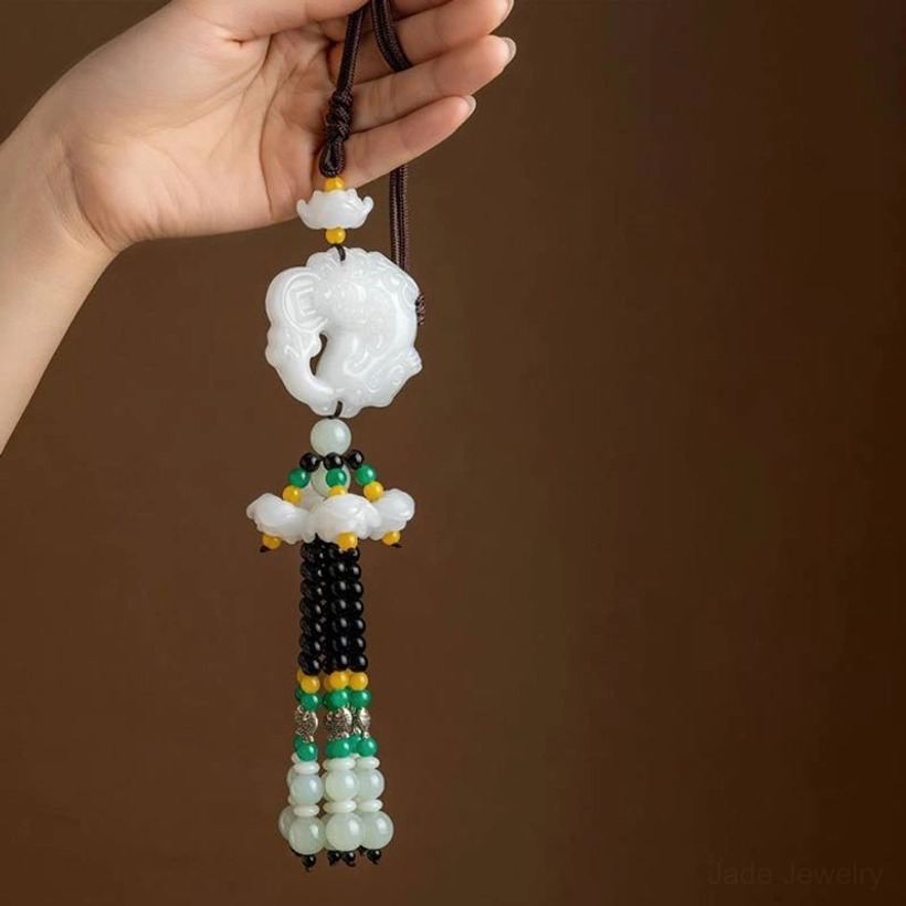 White jade Pixiu charm close-up with coin motif and matching jade stone accents, flat lay detail shot
