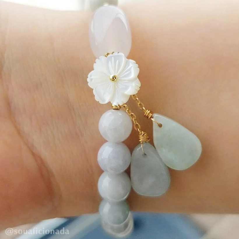 Natural white jade beaded bracelet featuring delicate flower charm and protective energy stones