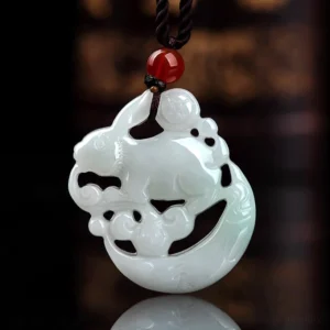Close-up overhead view of hand-carved white jade hollow relief rabbit and crescent moon pendant with intricate details