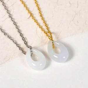 Pair of white jade teardrop pendants - silver and gold chain versions displayed together
