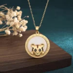 White jade tiger blessing necklace front view - golden tiger charm with engraved frame on white jade disc