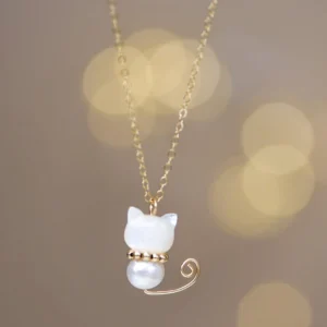 White shell Maneki-neko lucky cat pendant with pearl bead and gold-plated curled tail hanging necklace front view