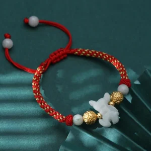 Chinese zodiac jade horse charm bracelet with red silk cord and sterling silver beads, flat lay top view